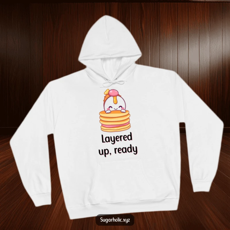 Funny hoodie featuring a smiling candy character peeking from behind a tempting stack of pancakes, perfect for cozy days.